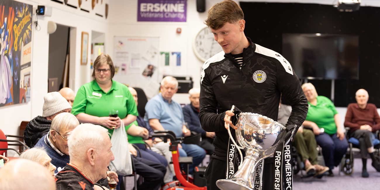 Mark O'Hara shows the trophy off to an older supporter