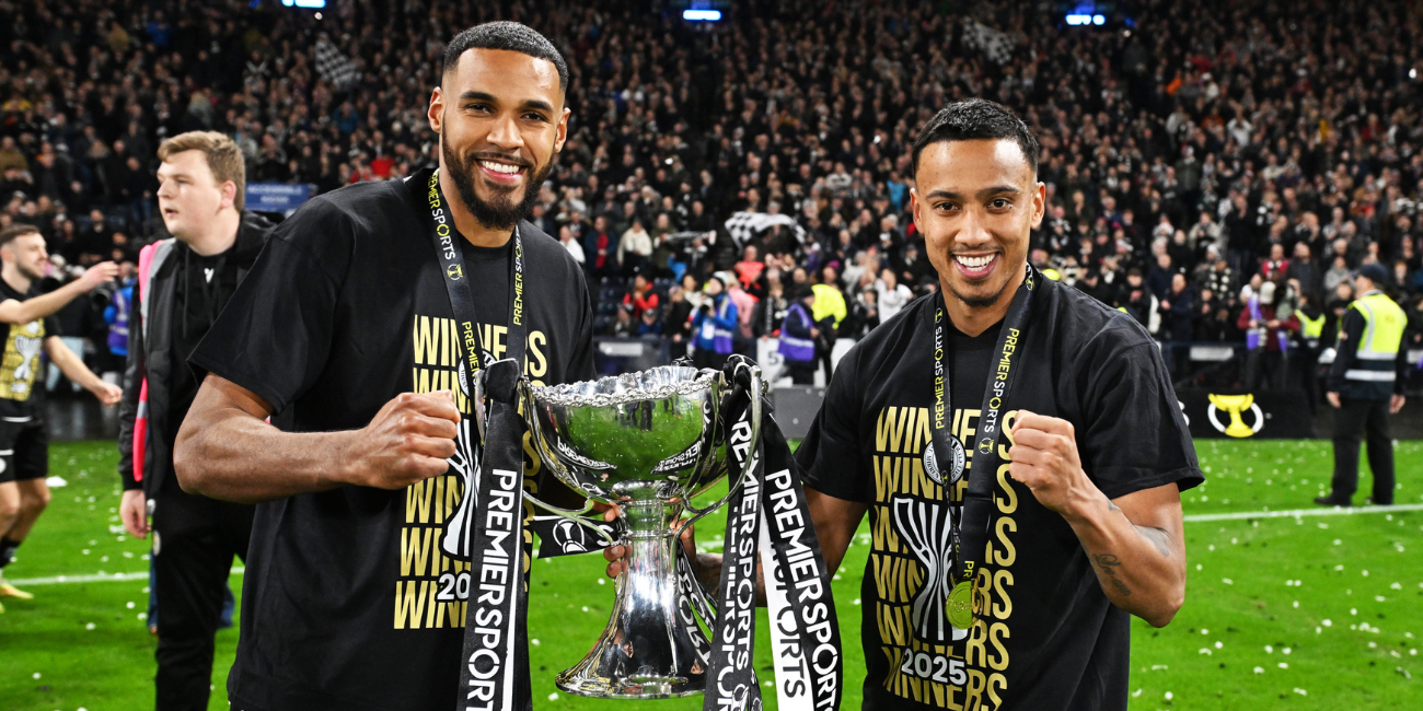 Jonah Ayunga and Keanu Baccus with the Premier Sports Cup Trophy